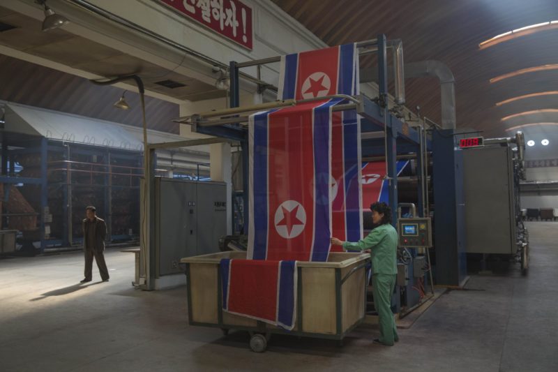 David Guttenfelder - A worker guided North Korean flags into a basket at the Kim Jong-suk factory in Pyongyang