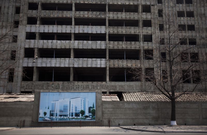 David Guttenfelder - In this April 13, 2011 photo, an illustration of a building project hangs in front of the construction project in progress in Pyongyang, North Korea