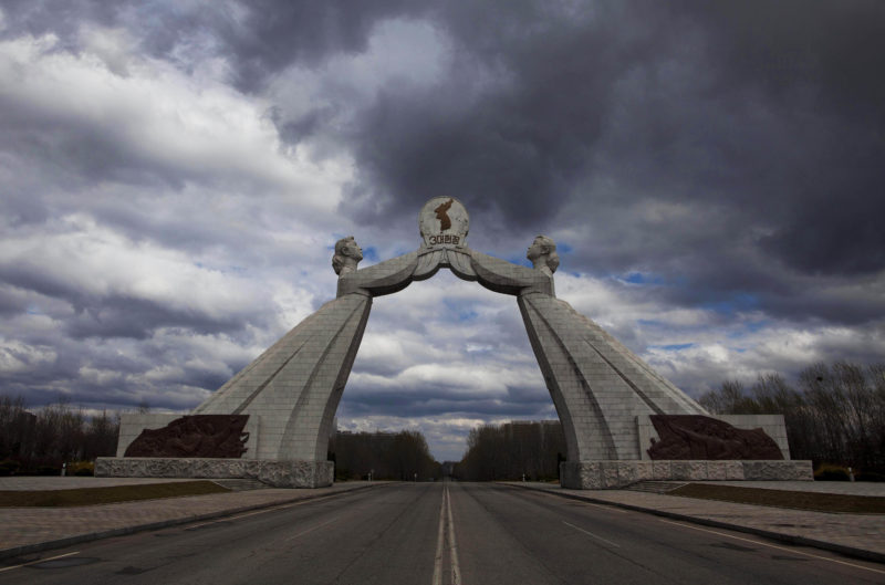 David Guttenfelder – A statue known as the Monument to the Three Charters for National Reunification, which symbolizes the hope for eventual reunification of the two Koreas, arches over a highway at the edge of Pyongyang, North Korea