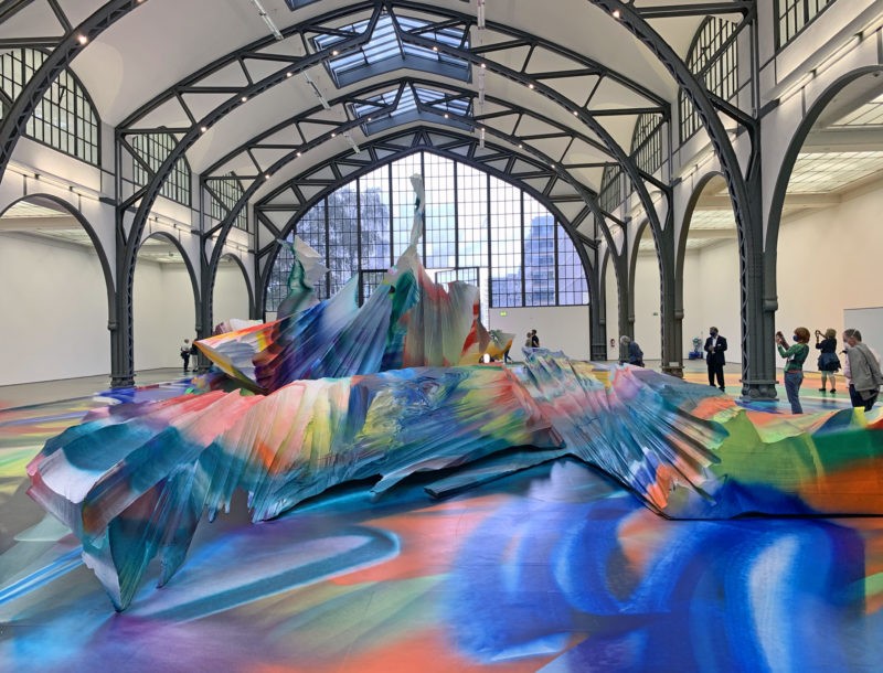 Katharina Grosse - It Wasn’t Us, 2020, acrylic on floor, polystyrene and bronze; paint on asphalt, concrete, brick and metal, 7 x 6,5 x 18,3 m, installation view, Hamburger Bahnhof, Berlin