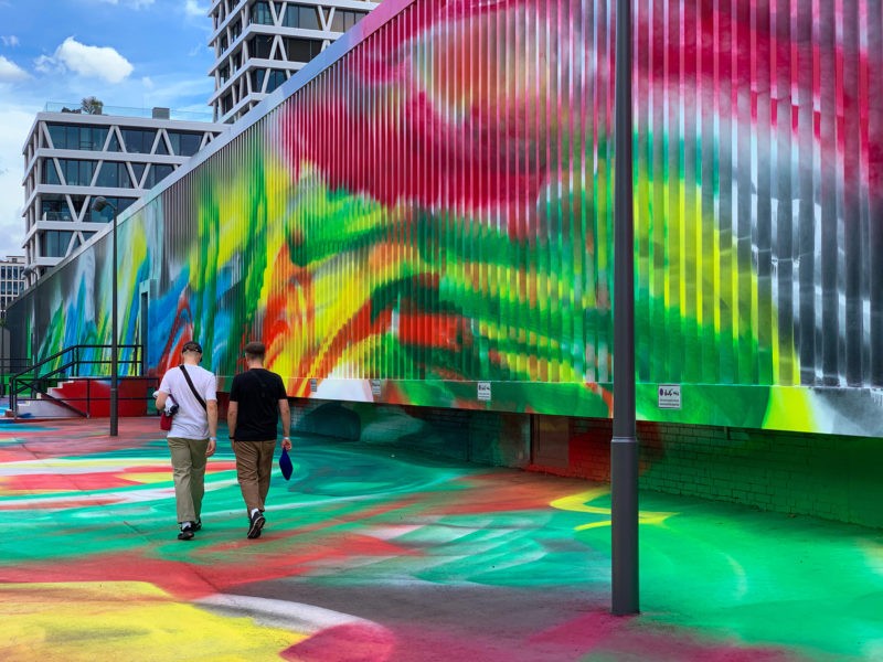 Katharina Grosse - It Wasn’t Us, 2020, acrylic on floor, polystyrene and bronze; paint on asphalt, concrete, brick and metal, 7 x 6,5 x 18,3 m, installation view, Hamburger Bahnhof, Berlin