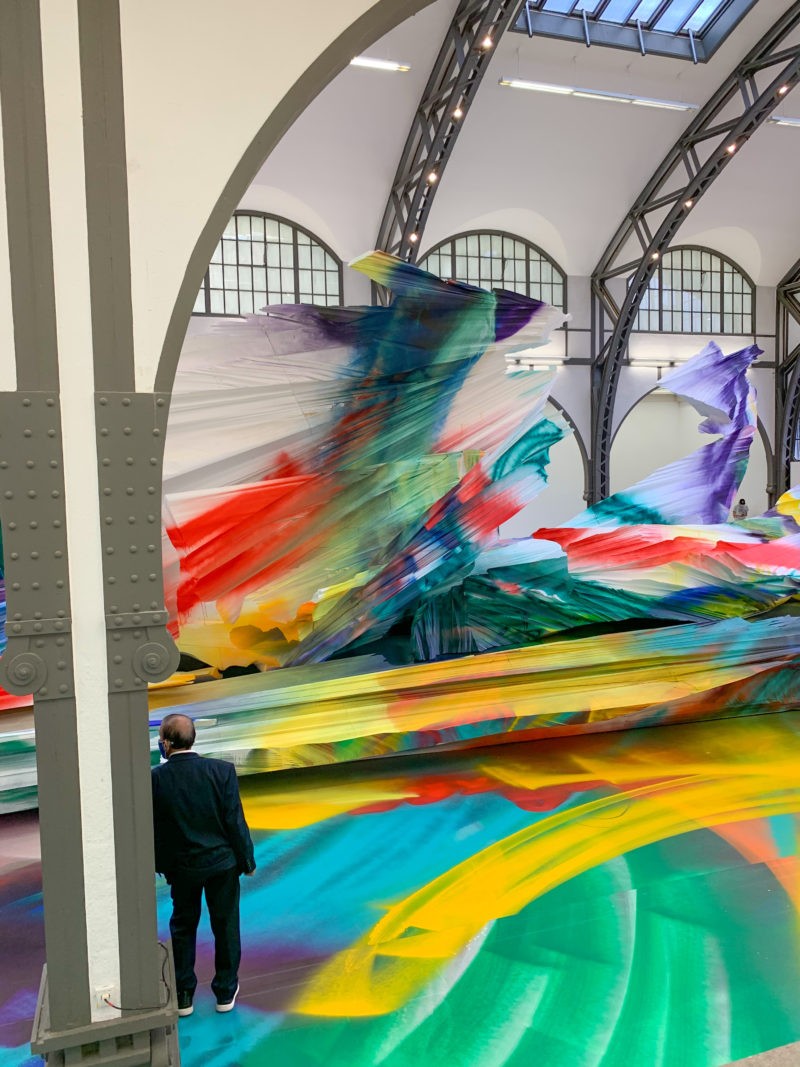 Katharina Grosse - It Wasn’t Us, 2020, acrylic on floor, polystyrene and bronze; paint on asphalt, concrete, brick and metal, 7 x 6,5 x 18,3 m, installation view, Hamburger Bahnhof, Berlin