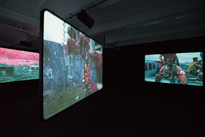 Richard Mosse - Installation view, The Enclave, 2012–2013. 16 mm infrared film transferred to HD video. Produced in eastern Democratic Republic of Congo. Courtesy of Jack Shainman Gallery, New York