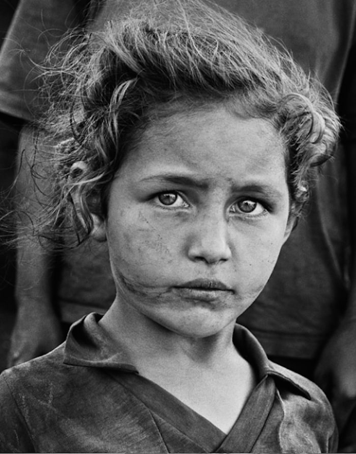 Sebastião Salgado - Little girl of landless family. More than 3,000 families have gathered at the edge of the national road while waiting for the occupation of land. Paraná, Brazil. 1996