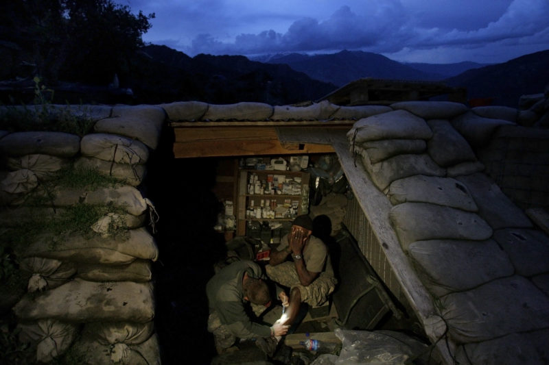 David Guttenfelder – Afghanistan - Spc. Cecil Montgomery of Many, LA, right, from the U.S. Army First Battalion, 26th Infantry, is treated by medic Pfc. Dorian Biberdorf of Bellevue, NB, inside a medical bunker at firebase Restrepo in the Korengal Valley of Afghanistan's Kunar Province on Saturday, May 9, 2009. Montgomery's leg, which was gashed in an operation two weeks ago, became infected and a medic had to open the wound to try to remove the infection and sterilize it.