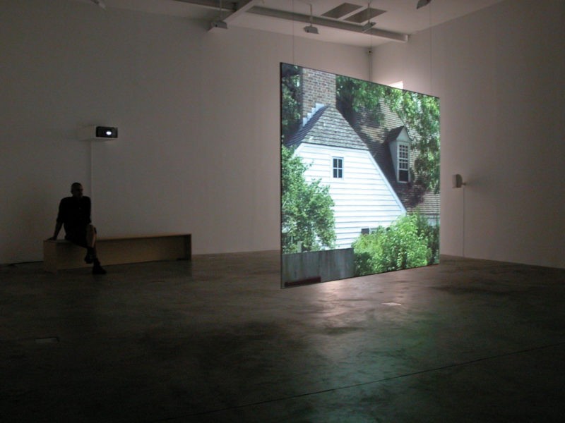 Omer Fast - Godville, 2005, Two channel video installation, 50 minutes, Installation view, Postmasters Gallery, New York