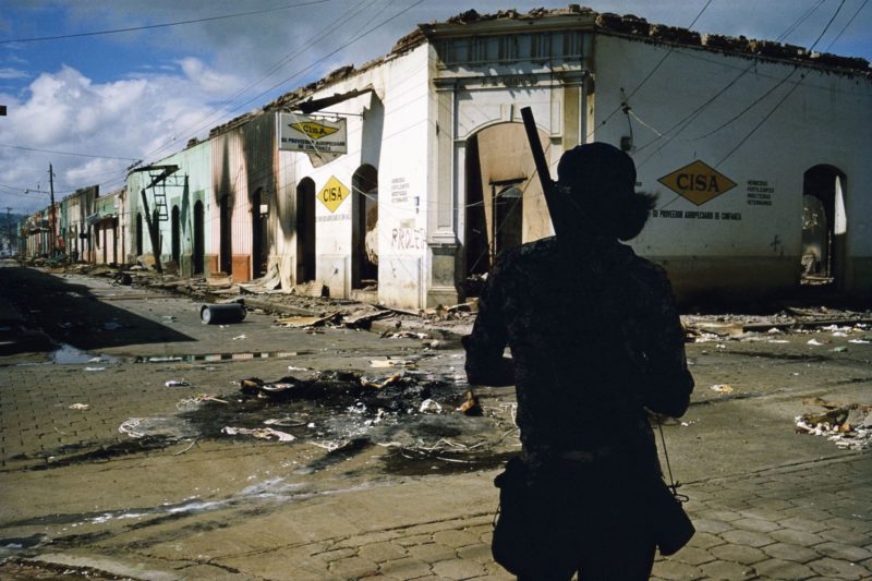 Susan Meiselas - Muchacho withdrawing from the commercial district of Masaya after three days of bombing, Masaya, Nicaragua