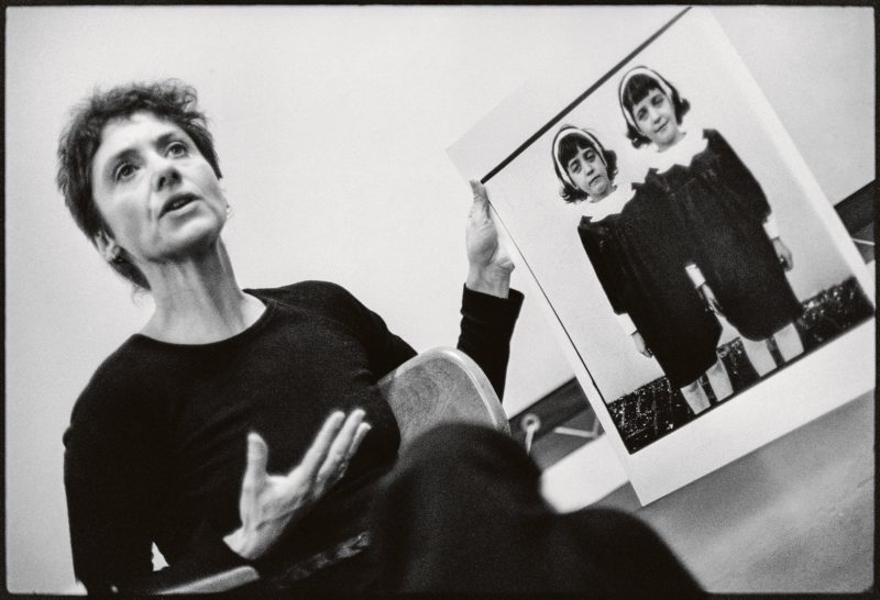 Diane Arbus with her photograph A family on their lawn one Sunday in Westchester, N.Y. 1968, during a lecture at the Rhode Island School of Design in 1970