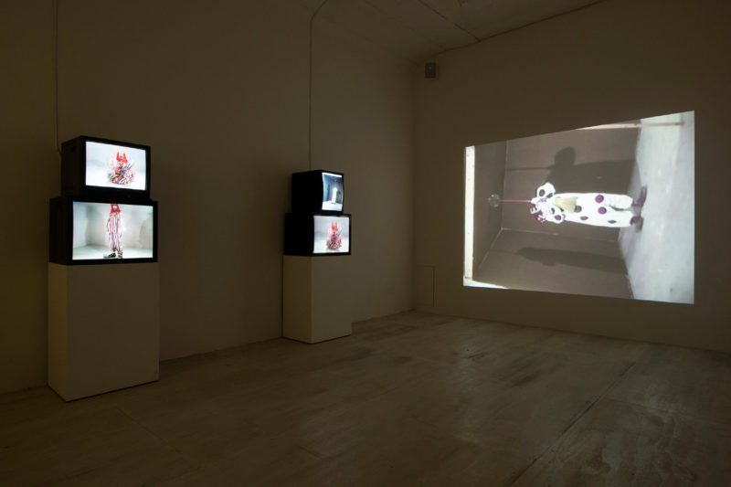 Bruce Nauman - Clown Torture, 1987, four-channel video installation, two projections, four monitors, color, sound, approx. 60 minutes, installation view, Museum of Modern Art, New York