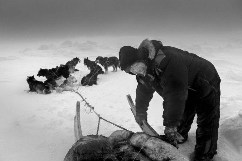 Ragnar Axelsson - Last Days of the Arctic - A hunter following polar bear tracks on the ice near Ittoqqortoormiit