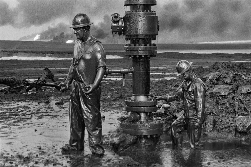 Sebastião Salgado – Greater Burhan Oil Field, Kuwait, 1991, Workers place a new wellhead in an oil well that had been damaged by Iraqi explosives