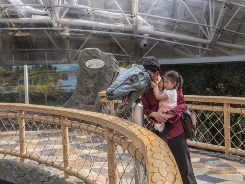 Carl De Keyzer - A man and his daughter learn about prehistoric life; Pyongyang Zoo. 28 May 2017 3.00 PM