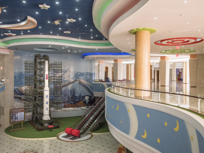Carl De Keyzer - Interior of the recently renovated Manggyondae Schoolchildren’s Palace. Pyongyang. The rocket is the Unha-3 (or ‘Galaxy-3’) carrier, designed to deliver payloads into space. 1 June 2017 4:00 PM