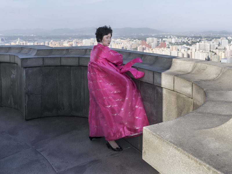 Carl De Keyzer - Tower of the Juche Idea, Pyongyang. Local guide and expert on the Pyongyang skyline, wearing traditional Korean dress. . 16 September 2015 4:00 PM