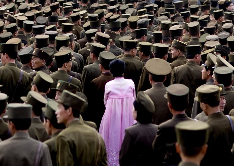 Eric Lafforgue – North Korea - A woman standing in the middle of a crowd of soldiers. This picture is not supposed to be taken as officials do not allow army pictures