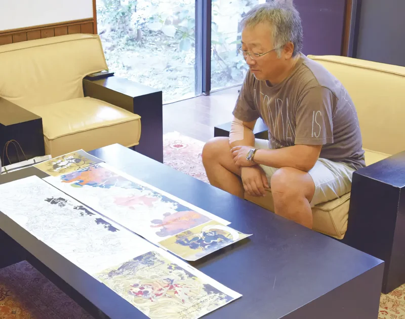 Katsuhiro Otomo with a sketch of Kinka Doji Riding the Waves Accompanied by Fujin and Raijin, 2014