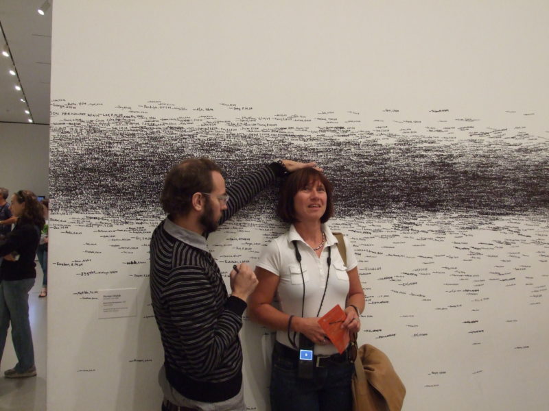 Visitors in Roman Ondak's Measuring the Universe, 2007, performance, felt-tip pen, museum guards, museum audience, installation view, Museum of Modern Art, New York, 2009