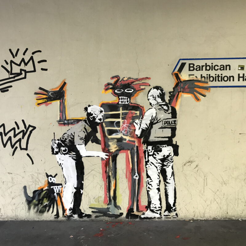 Banksy - Portrait of Basquiat being welcomed by the Metropolitan police, 2017, installation view, Barbican Center, London, England