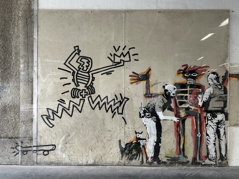 Banksy – Portrait of Basquiat being welcomed by the Metropolitan police, 2017, installation view, Barbican Center, London, England